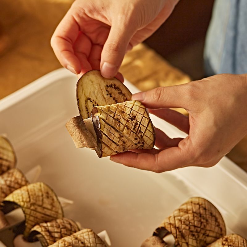 전자레인지에서 익힌 가지에 새송이버섯을 넣고 돌돌 말아주세요.