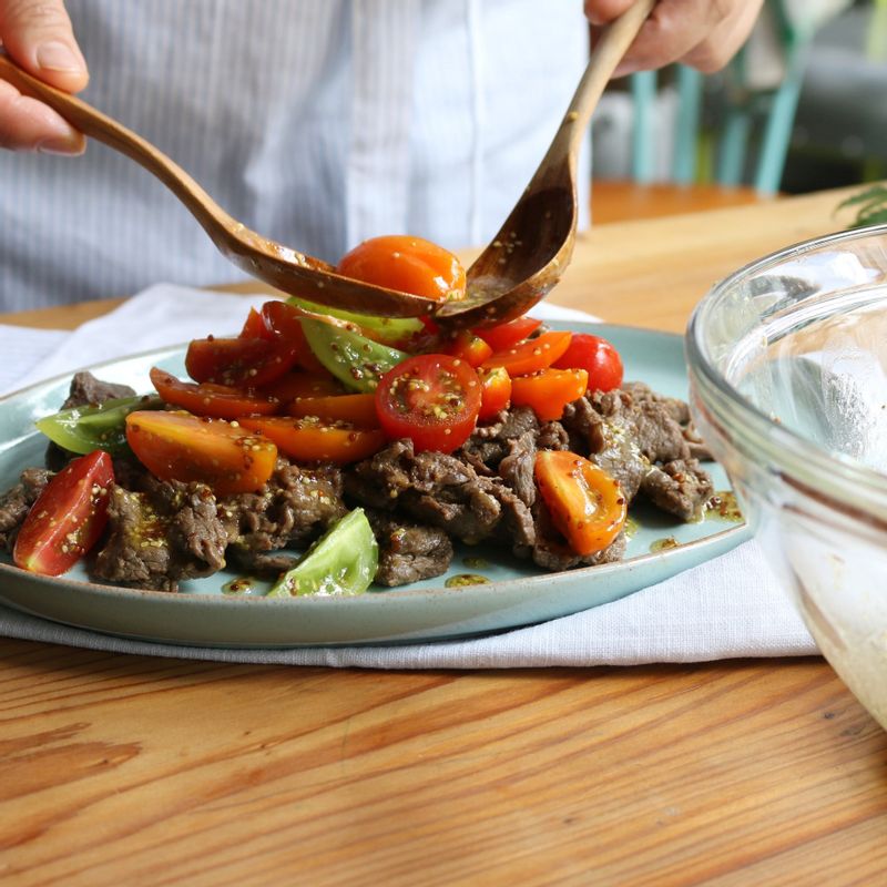 그릇에 쇠고기-체리토마토-어린잎채소 순으로 올려내주세요. 쇠고기를 약간 식힌 후에 올려야 채소의 아삭함이 잘 살아요.