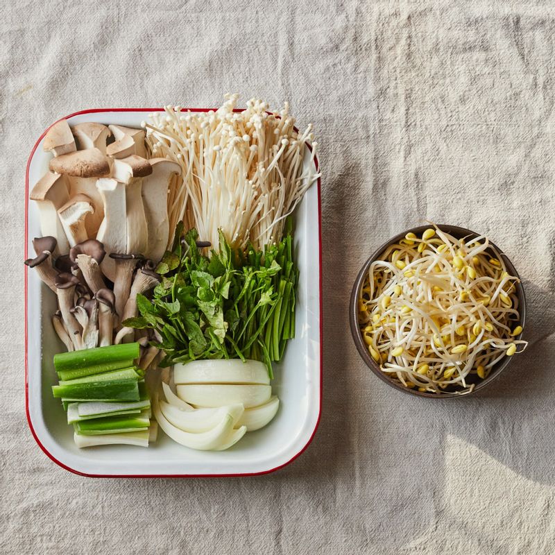 대파는 길이로 반을 가른 후 6cm로 길이로 자르고 팽이버섯은 밑동을 잘라주세요. 새송이버섯은 먹기 좋게 자르고 양파는 굵게 채를 썰어주세요. 콩나물과 미나리는 깨끗이 씻고 미나리는 6cm 길이로 잘라주세요. 볼에 양념장 재료를 넣고 섞어 양념장을 만들어주세요.