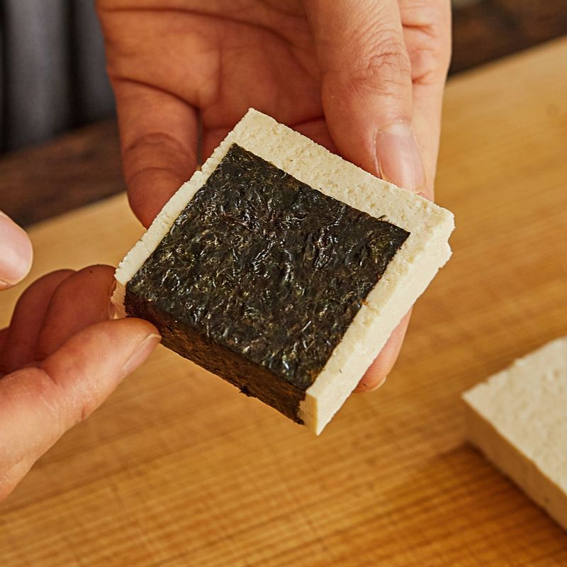 두부를 김으로 감싼 후 전분 가루를 앞뒤로 살짝 묻혀주세요.
(Tip. 열을 가하면 김의 크기가 줄어들기 때문에 김은 너무 작게 붙이지 않는 것이 좋아요.)