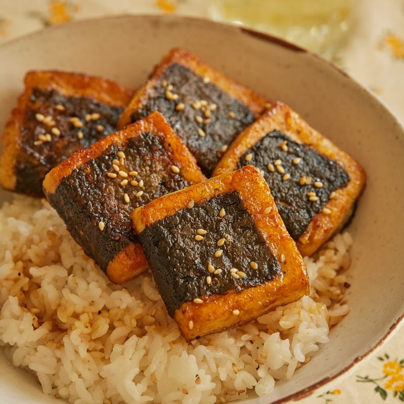 그릇에 밥을 담은 후 남은 양념을 밥에 끼얹어주세요. 두부를 가지런히 올린 후 통깨를 뿌려 완성해 주세요.
(기호에 따라 쪽파 등을 뿌려 드셔도 좋답니다.)