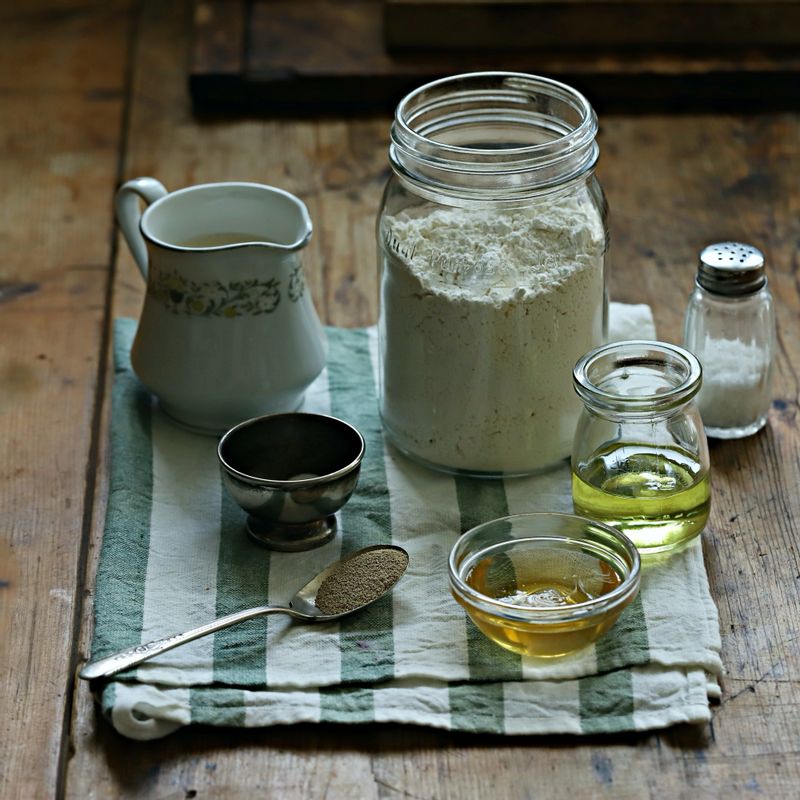 비건 식빵을 위한 재료 이미지로 강력분,드라이이스트 (골드),소금,포도씨 오일 (또는 올리브 오일),메이플시럽 (또는 꿀) 등으로 구성 되어있습니다.