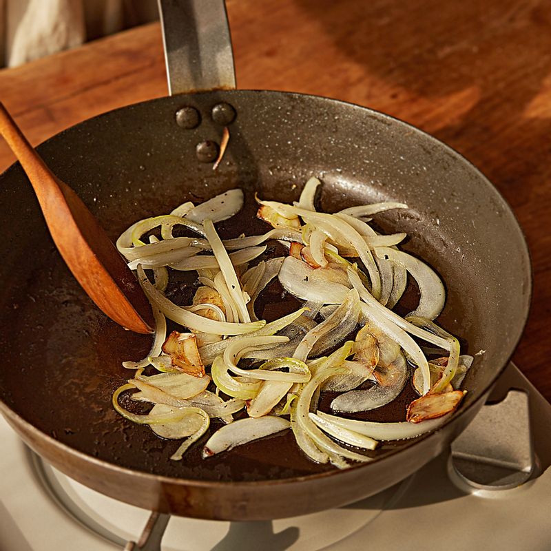 달군 팬에 식용유를 두른 후 마늘을 넣어 볶다가 향이 나면 양파를 넣고 소금과 후추를 뿌려 볶아주세요.