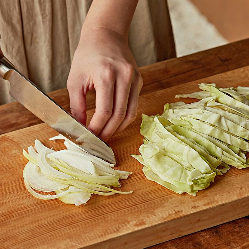 양배추와 양파는 채를 썰어주세요. 마늘은 편으로 썰고 쪽파는 송송 썰어주세요. 밑동 부분을 자른 팽이버섯은 먹기 좋게 손질해 주세요.