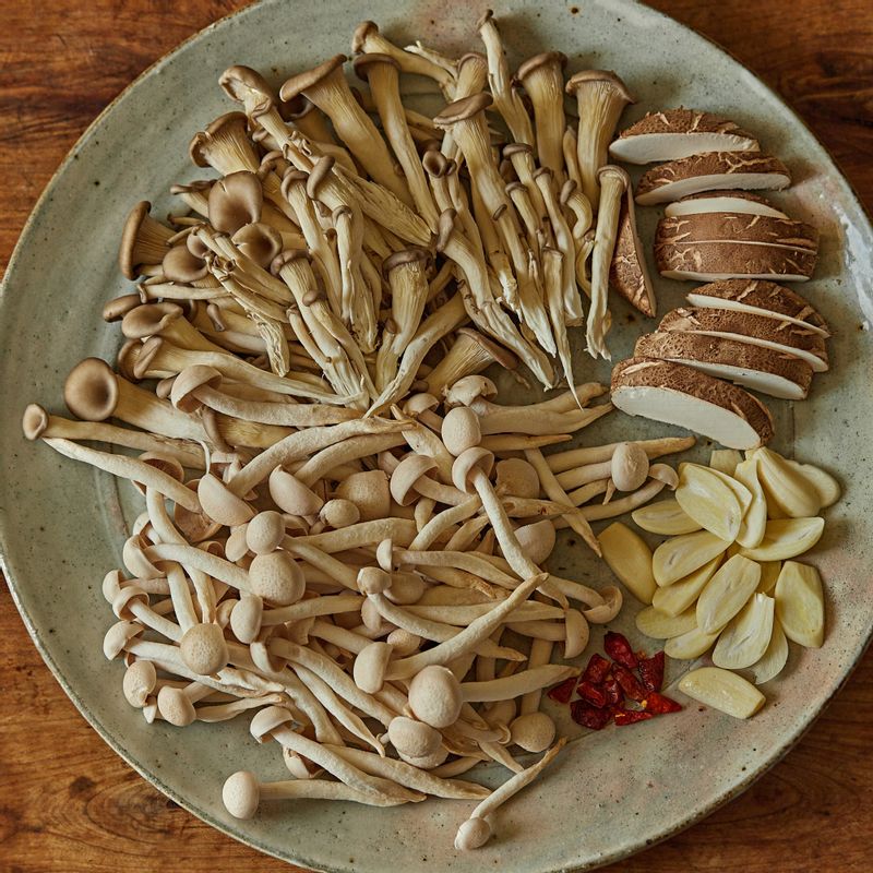 만가닥 버섯과 느타리버섯, 표고버섯은 밑동을 제거하고 불순물을 털어내주세요. 표고버섯은 한 입 크기로 썰고, 마늘은 편으로 도톰하게 썰어주세요. 페페론치노는 반으로 잘라주세요.