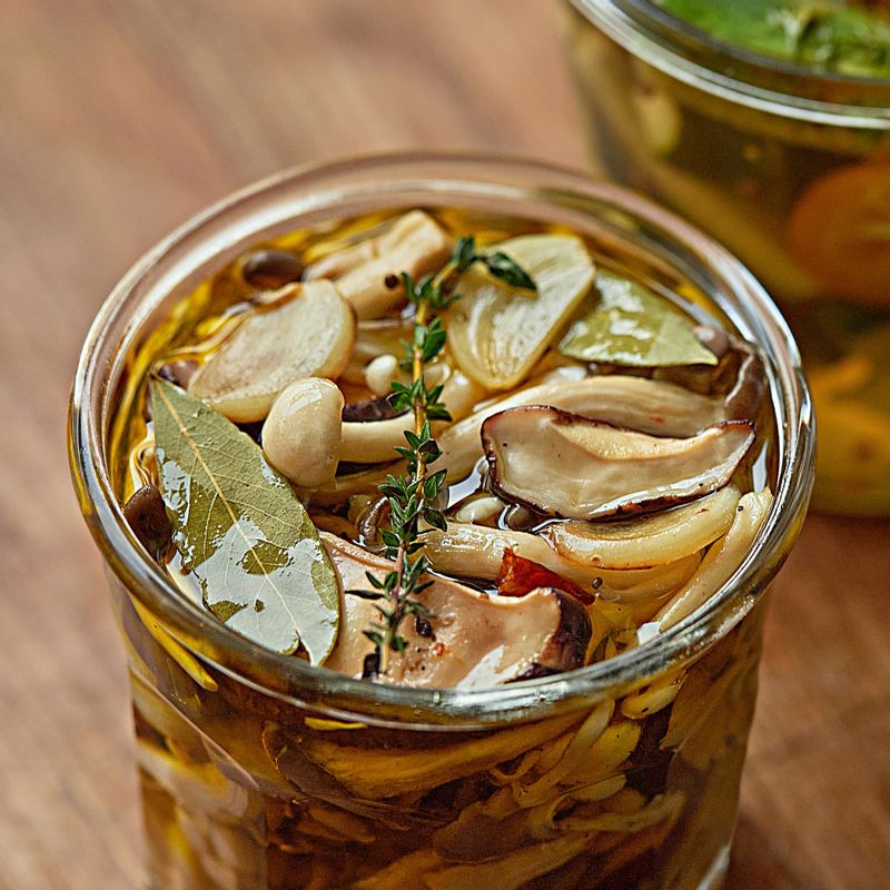 소독한 유리병에 식힌 버섯을 8부 정도 담고 올리브오일을 부어 병을 채운 후 월계수잎과 타임을 얹고 뚜껑을 닫아 냉장 보관 해주세요.