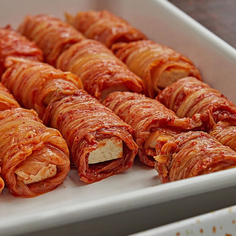 김치를 넓게 깔고, 구운 두부를 올려 돌돌 말아주세요.