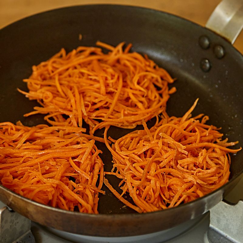 달군 팬에 식용유를 두르고 당근을 올려 둥글게 모양을 만들어 주세요. 한쪽 면이 잘 익으면 뒤집어 다른 면도 익혀 주세요.