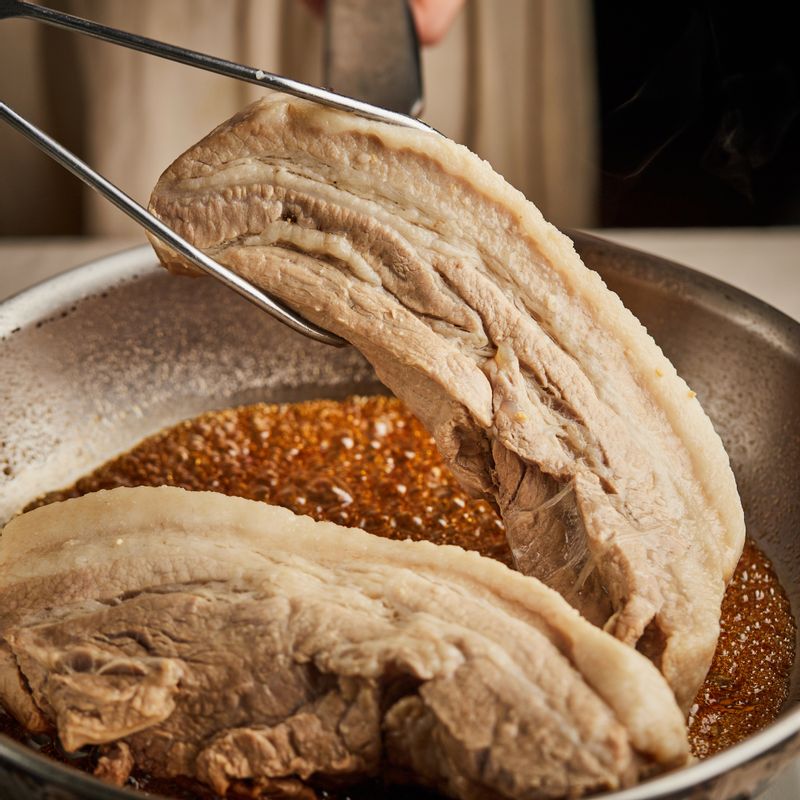 팬에 간장 소스 재료를 넣고 소스가 보글보글 끓으면 삶은 돼지고기를 얹고 약한불에서 앞뒤로 뒤집어가며 윤기 나게 2분 정도 졸여주세요.