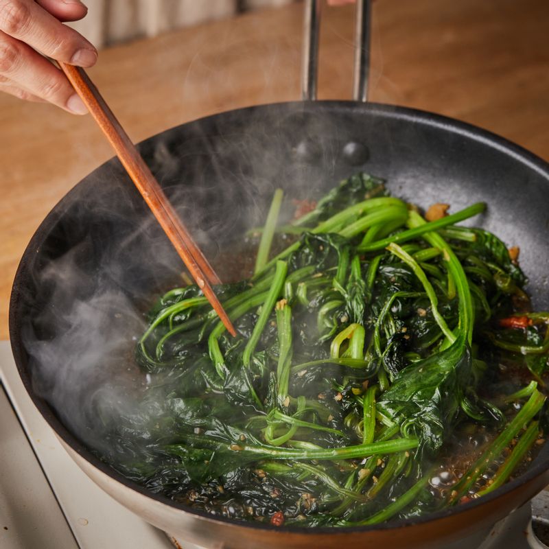 달군 팬에 기름을 두르고 다진 마늘 1큰술을 넣어 볶다가 시금치, 페페론치노를 넣고 볶아주세요. 시금치가 반쯤 볶아졌을 때 간장과 설탕, 후춧가루로 간을 해주세요.