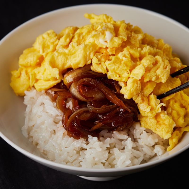 그릇에 밥을 담고 밥 위에 볶은 양파와 소스를 넣고 스크램블 에그를 올린 후 돈가스를 올려주세요.