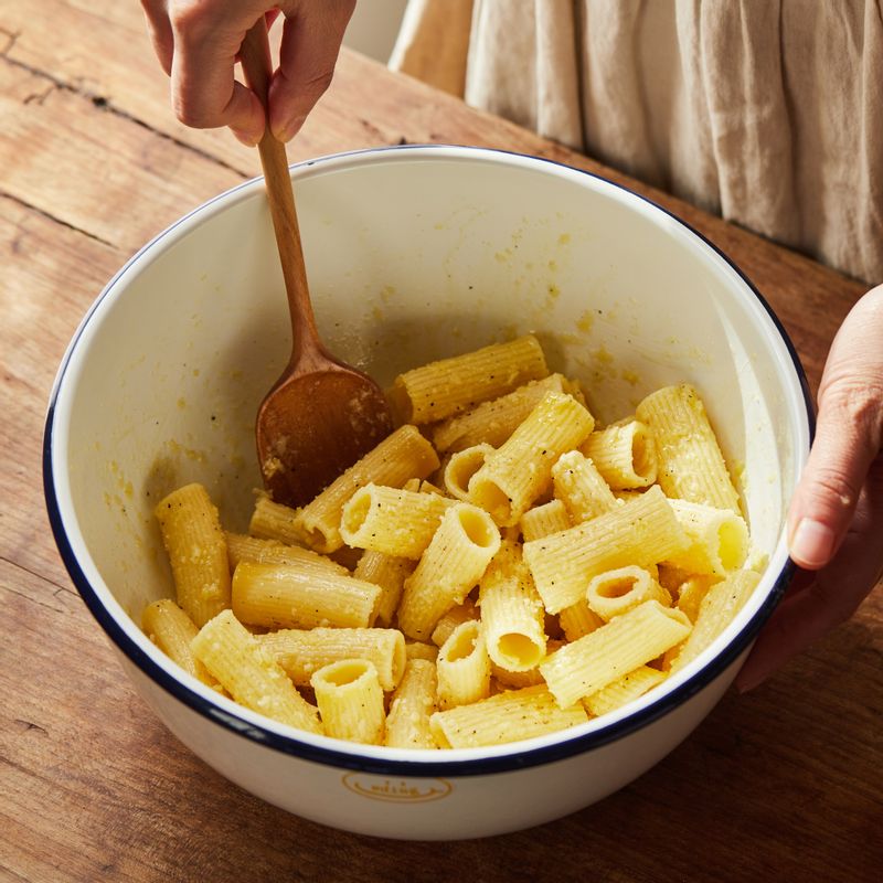 넓은 볼에 삶은 리가토니와 올리브오일, 소금, 후춧가루를 넣고 파마산 치즈를 갈아 넣어 섞어주세요.