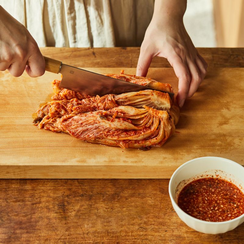 김치는 속 재료를 털어내고 꼭지를 붙인 채 3등분하여 썰어주세요. 볼에 양념장 재료를 넣고 섞어 양념장을 만들어주세요.
(tip.김치의 숙성 정도에 따라 설탕을 가감해주세요)