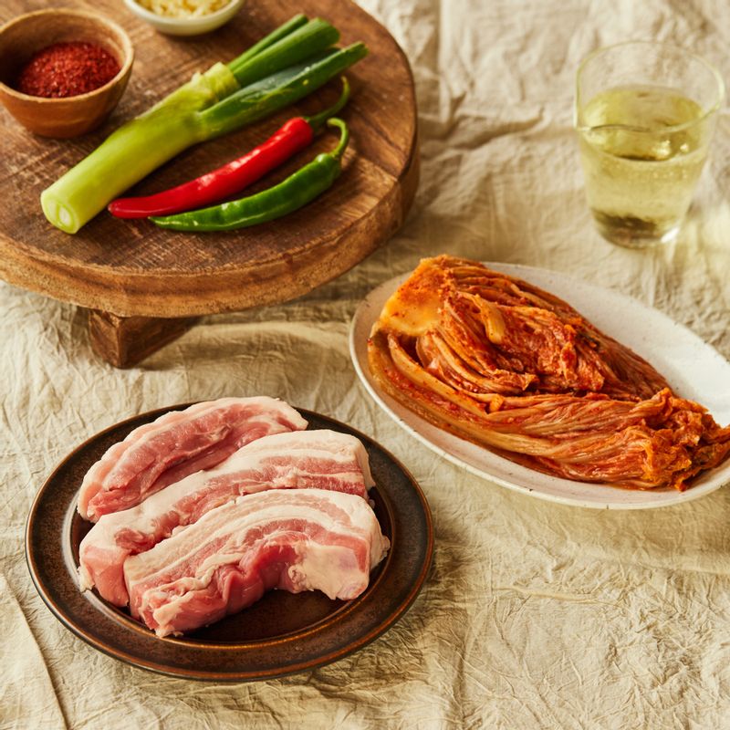 돼지고기 김치찜을 위한 재료 이미지로 통삼겹살(또는 목살),신김치,대파,홍고추,청양고추 등으로 구성 되어있습니다.