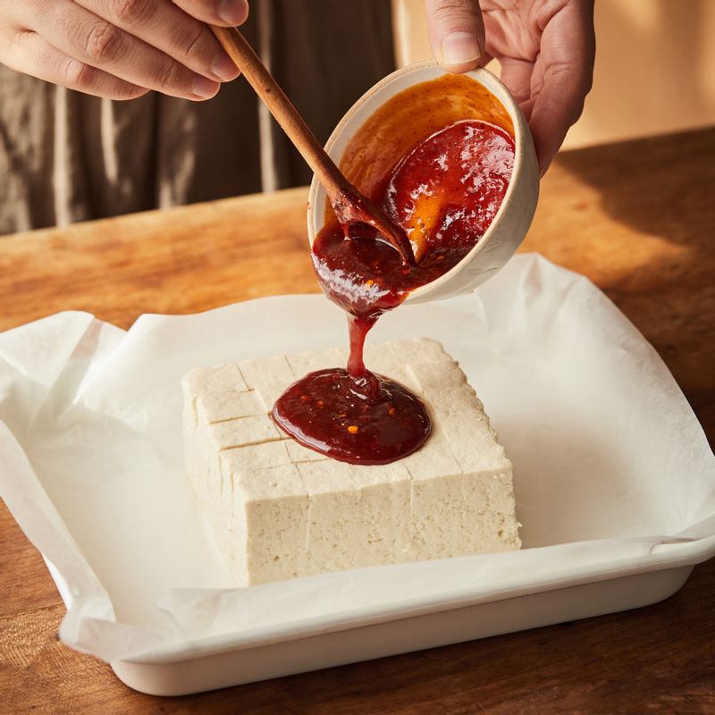 내열 용기에 종이호일을 깔고 두부를 올린 후 양념을 얹어주세요.