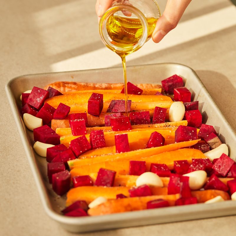 내열 용기에 당근과 비트, 마늘을 올리고 올리브유, 메이플시럽, 소금, 후춧가루를 골고루 뿌려주세요.