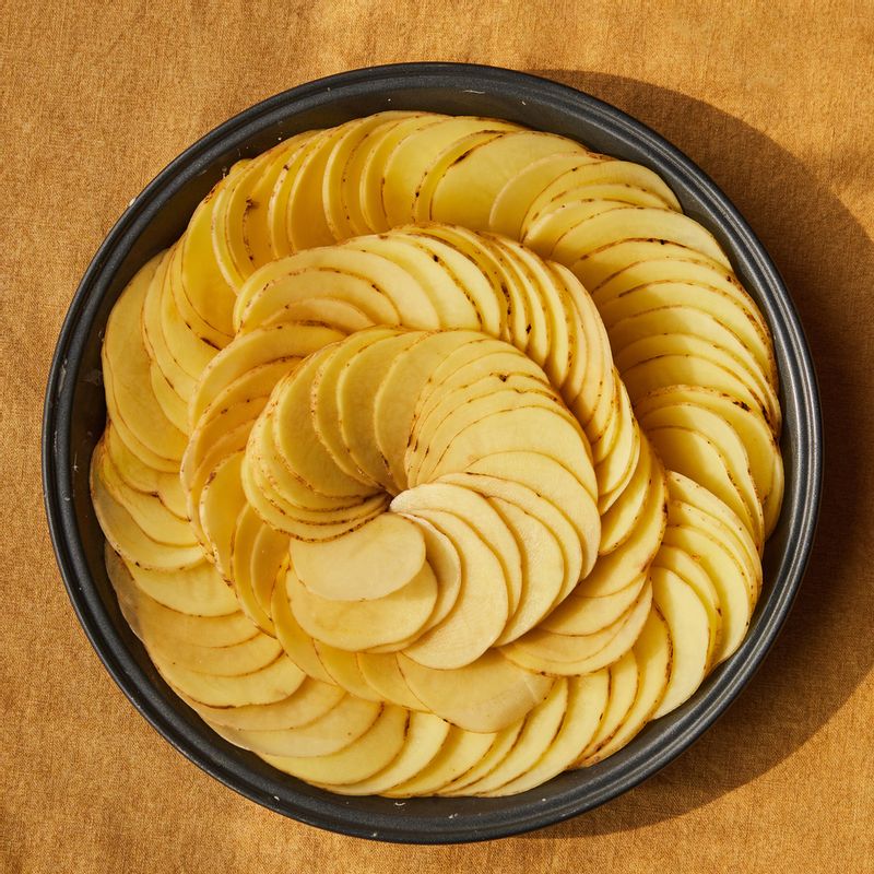 내열 용기에 버터를 약간 바른 후 볶은 양파와 마늘을 깔고 슬라이스 한 감자를 빼곡히 둘러 담은 후 생크림을 부어 윗면을 포일로 감싸주세요.