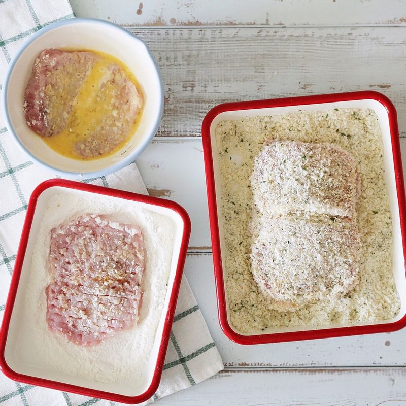 빵가루를 넓은 그릇에 담고 파슬리가루를 잘 섞어주세요. 밀가루, 달걀물도 각각 넓은 그릇에 담습니다. 돼지고기에 밀가루-달걀물-빵가루 순으로 튀김옷을 입혀주세요.