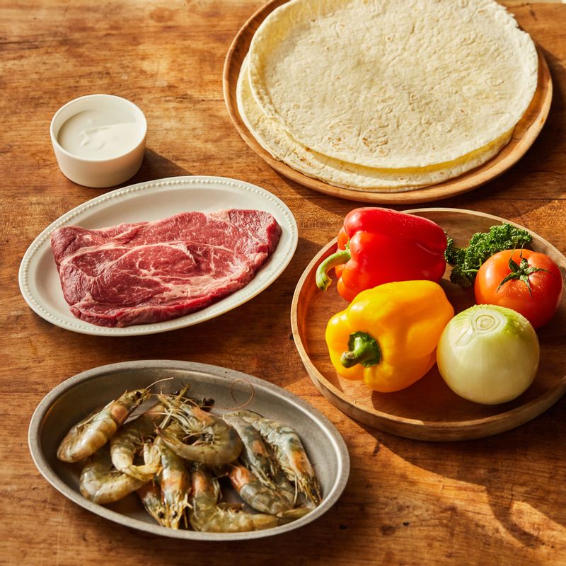 스테이크 화이타을 위한 재료 이미지로 구이용 쇠고기,새우,빨간, 노란 파프리카,토마토,양파 등으로 구성 되어있습니다.