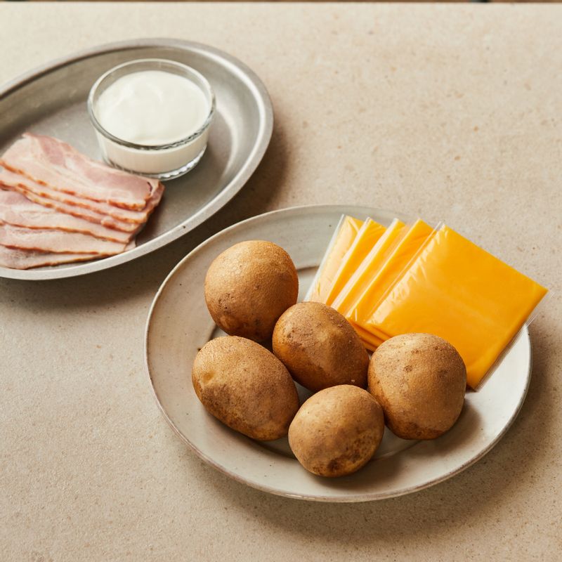 감자 버터 오븐구이을 위한 재료 이미지로 감자,베이컨,체다 슬라이스 치즈,플레인 요거트,파슬리가루 등으로 구성 되어있습니다.