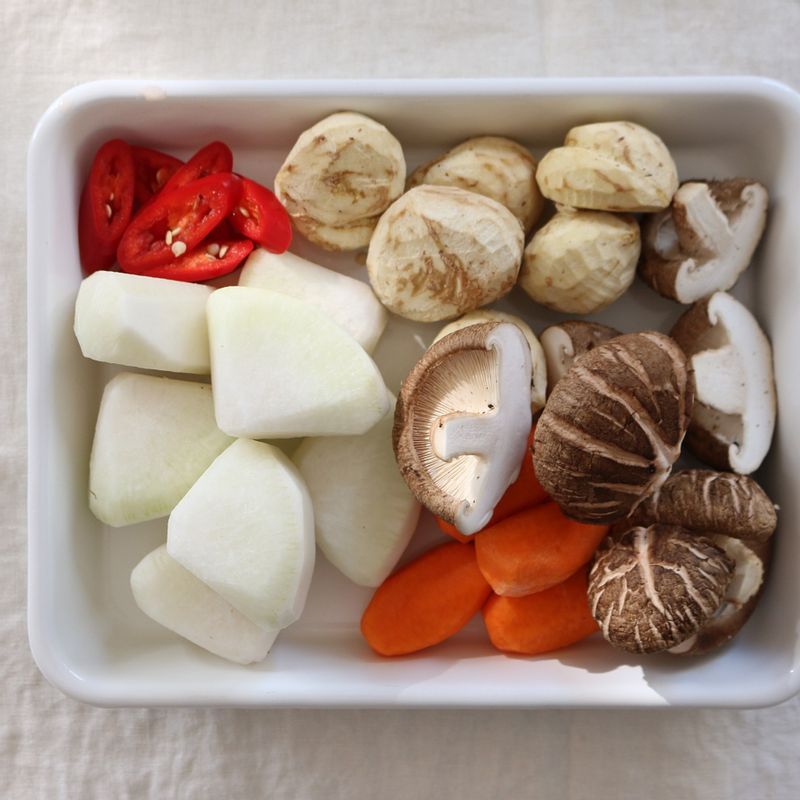 무와 당근은 한입 크기로 자른 후 모서리를 둥글게 다듬고 홍고추는 어슷하게 썰어줍니다. 표고버섯은 4등분하고 밤은 껍질을 까주세요.