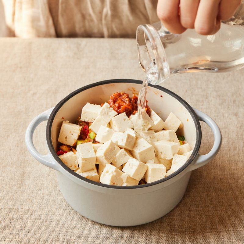 냄비에 손질한 채소와 양념 재료를 넣고 섞은 후 멸치 다시마 물을 붓고 뚜껑이나 포일을 덮어주세요.