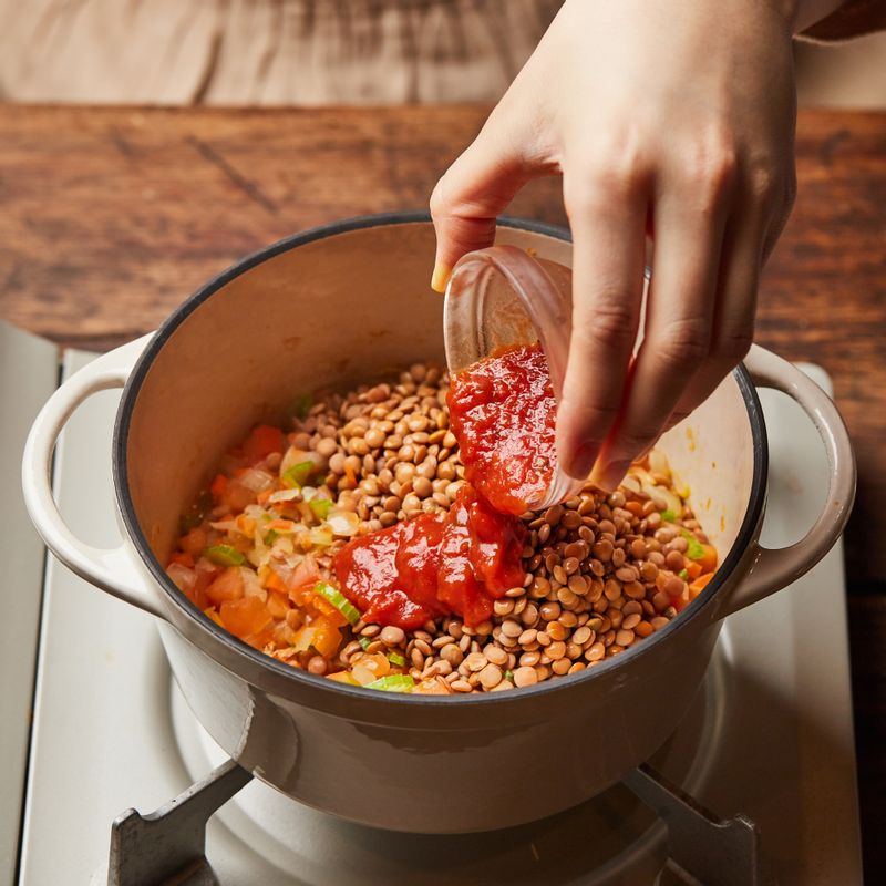 토마토소스와 불린 렌틸콩, 물을 넣고 큐민과 허브를 넣은 후 뚜껑을 덮어 중불에서 20분간 끓여주세요.
