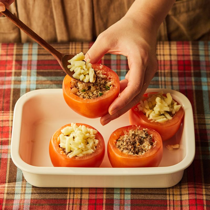 토마토 속에 볶은 재료를 80% 정도 채우고 그 위에 모짜렐라 치즈를 채운 후 토마토 뚜껑을 닫아주세요. 토마토를 내열 용기에 담고 올리브 오일을 약간 뿌려주세요.