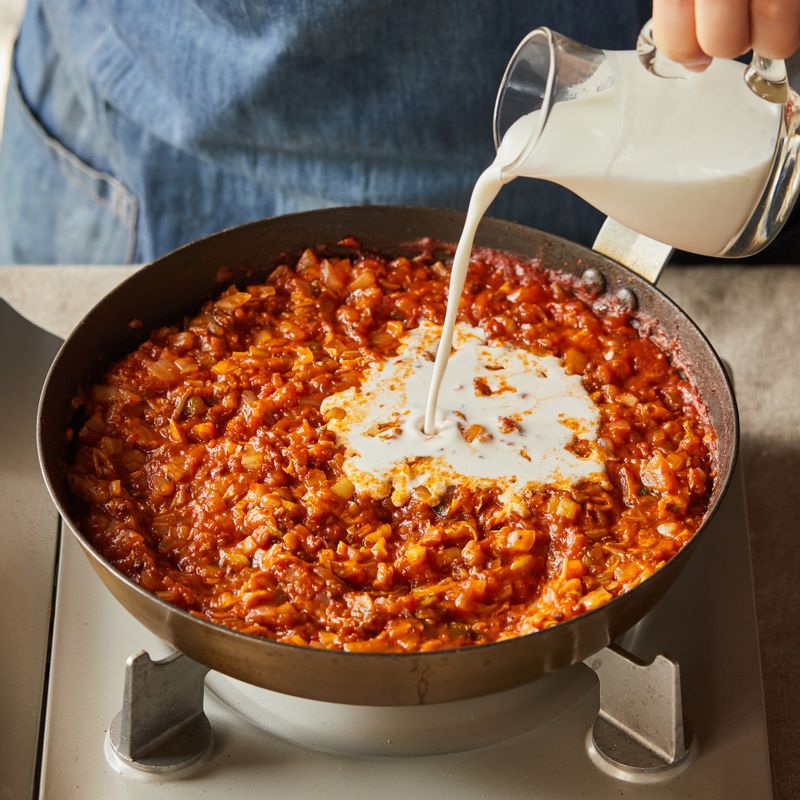 볼로네제 소스를 넣고 소금, 후춧가루로 간을 한 후 저어가며 3~4분간 끓이다가 생크림을 넣고 2분간 끓여 소스를 완성해 주세요.