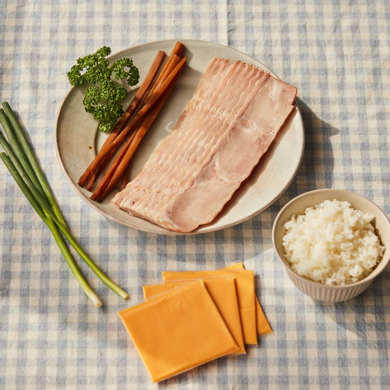 베이컨 치즈말이밥을 위한 재료 이미지로 베이컨,슬라이스 치즈,김밥용 우엉,밥,파슬리(또는 쪽파) 등으로 구성 되어있습니다.