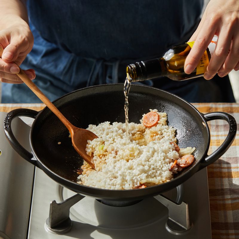 달군 팬에 올리브오일을 약간 두른 후 다진 마늘과 초리조, 양파를 넣고 볶다가 불린 쌀과 화이트 와인을 넣어 볶아주세요.
(tip. "오븐 사용이 가능한 팬을 사용해주세요.
화이트와인 대신 청주를 사용해도 좋아요.")