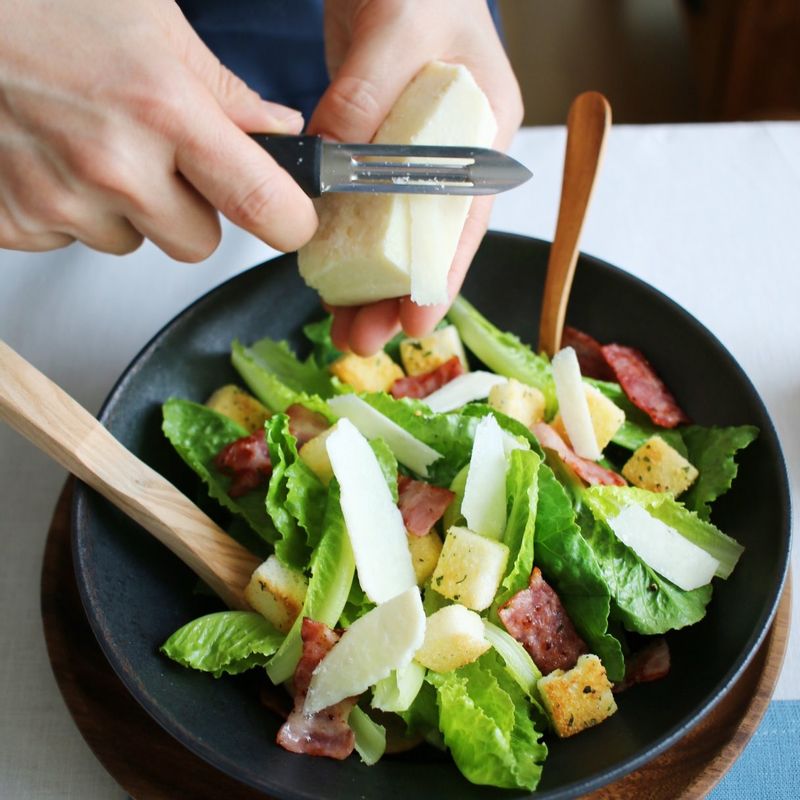 그릇에 로메인상추를 담고 베이컨과 크루통을 얹은 후 파르메산치즈와 드레싱을 뿌려주세요.