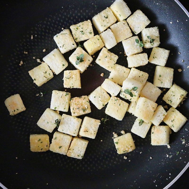 달군 팬에 식빵을 올려 노릇하게 구운 후 따로 빼놓습니다. 팬에 버터를 녹이고 구운 식빵과 나머지 크루통 재료를 넣어 골고루 섞어서 구워주세요.