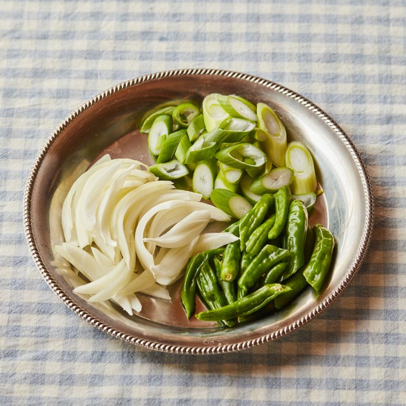 양파는 굵게 채 썰고 대파는 어슷하게 썰어주세요. 꽈리고추는 어슷하게 반으로 썰어주세요.