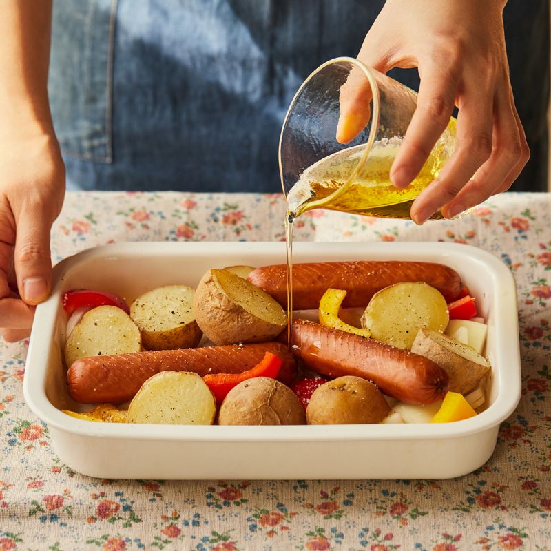 내열 용기에 감자와 소시지, 채소를 넣고 밑간 재료를 넣어 버무려주세요.