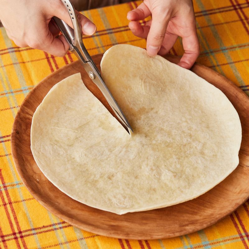 가위로 토르티야의 중앙까지 자른 후 꼬깔콘 모양으로 말아서 닭 다리 살과 구운 채소, 과카몰리를 넣은 후 치즈를 뿌려 완성해 주세요.