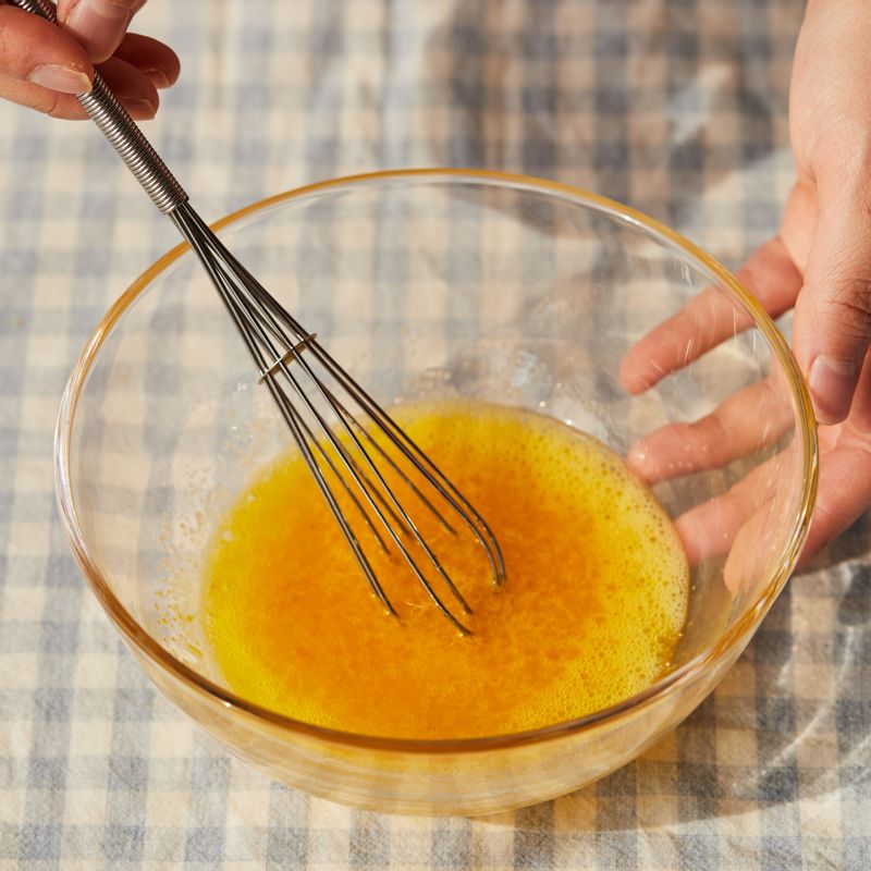 볼에 달걀을 넣어 풀어준 후 섞어둔 레몬 제스트와 설탕을 넣고 섞어주세요.