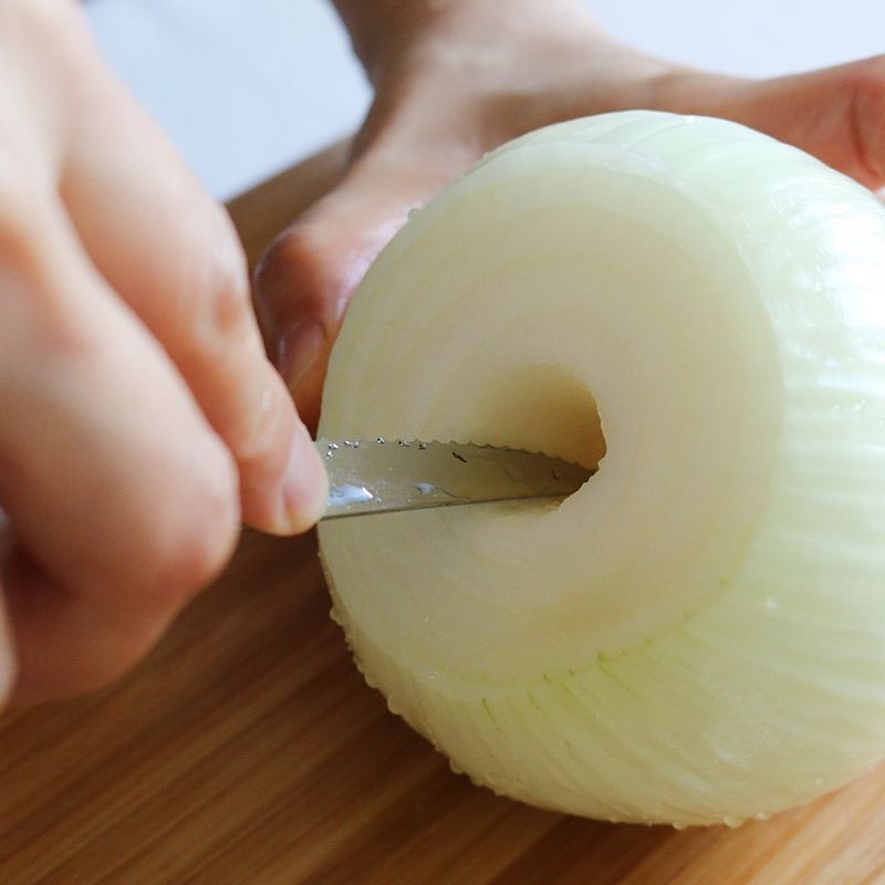 양파는 껍질을 벗긴 후 뿌리 부분은 그대로 살리고 윗부분만 잘라냅니다. 잘라낸 면의 중앙을 칼로 동그랗게 파내주세요.