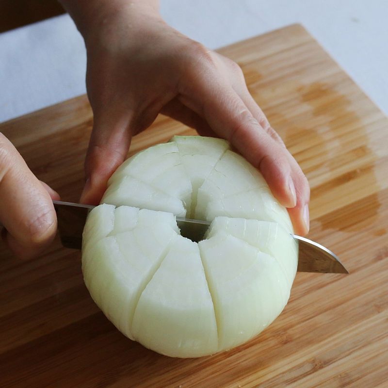 양파 뿌리 부분은 1cm 남기고 16등분으로 칼집을 넣어주세요. 양파 밑에 나무젓가락을 받치고 칼집을 넣으면 밑부분이 잘리지 않게 칼집을 넣을 수 있어요.