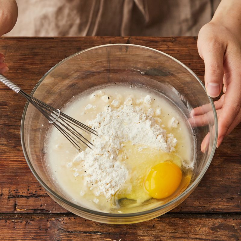 볼에 반죽 재료를 넣고 고루 섞은 후 양배추, 쪽파, 양파, 오징어, 베이컨을 넣어 섞어주세요.