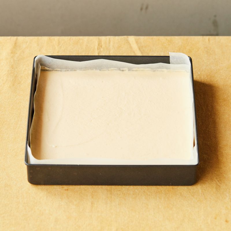 종이 포일을 깔아둔 오븐 팬에 반죽을 넣고 스크래퍼 또는 주걱으로 반죽을 평평하게 펼쳐주세요. 바닥에 2~3번 내리쳐 기포를 빼주세요.