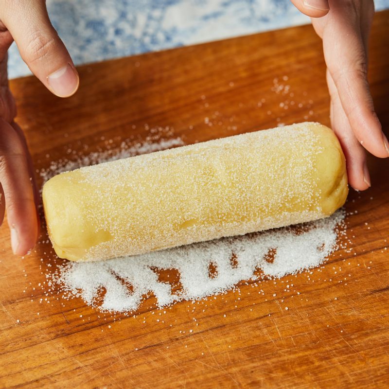 도마에 설탕을 뿌려 반죽을 굴리고 1cm 두께로 잘라 법랑 접시 위에 올려주세요.
