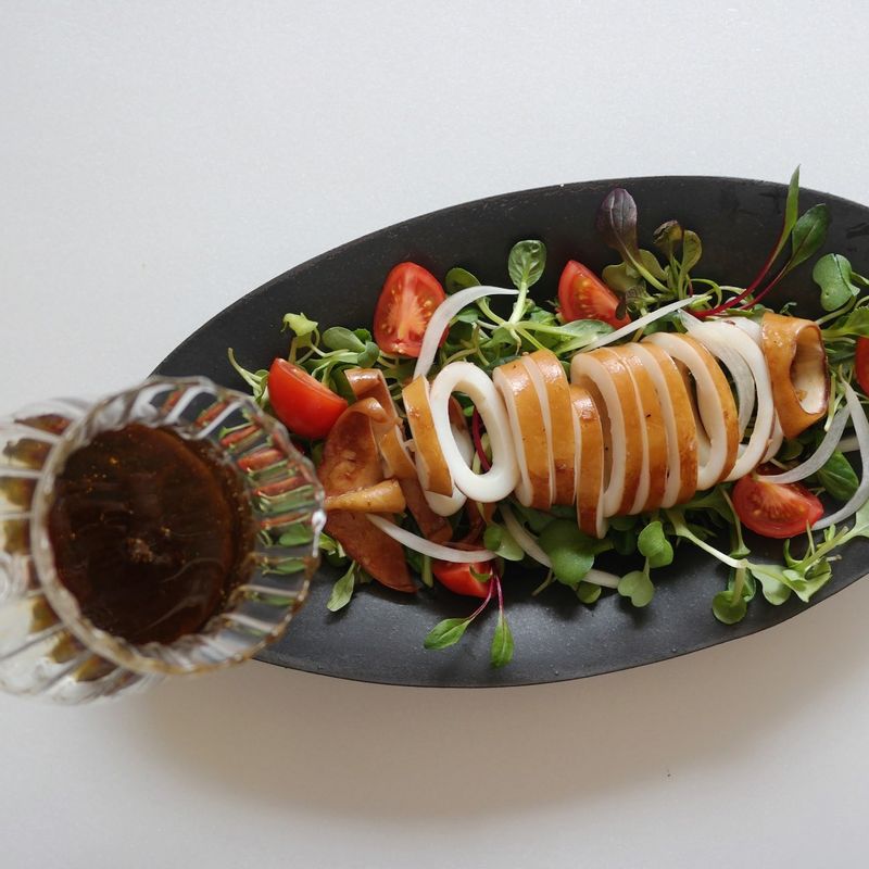 어린잎채소 위에 방울토마토, 오렌지, 양파, 오징어를 골고루 올려주세요.