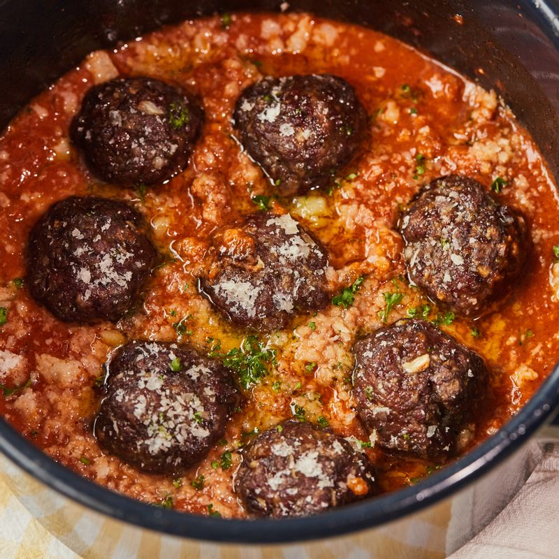 토마토소스에 익힌 미트볼을 넣고 파마산 치즈 가루, 다진 파슬리를 뿌려 가볍게 섞어주세요.