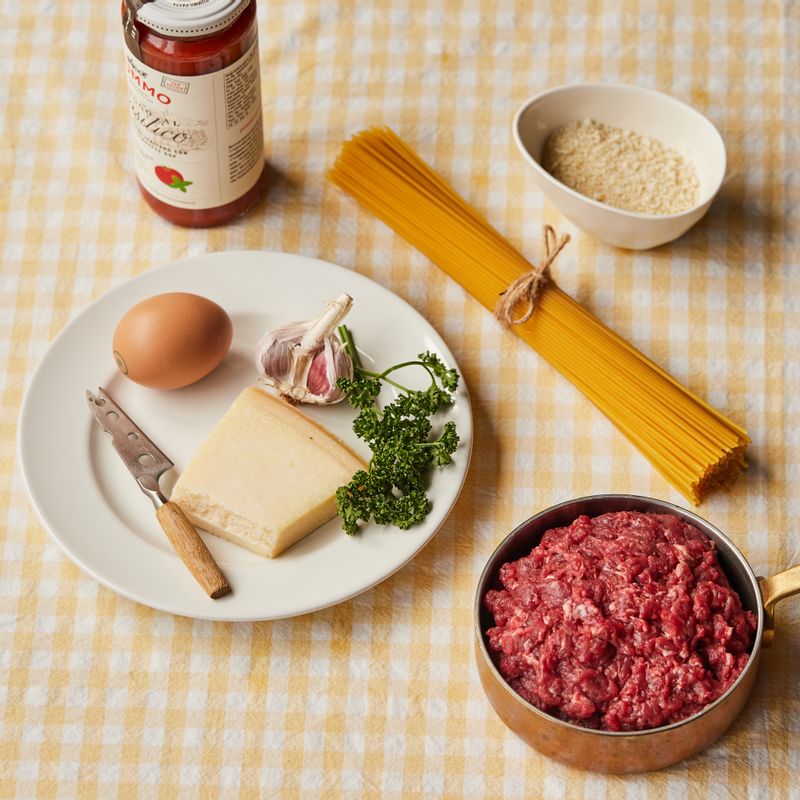 미트볼 스파게티을 위한 재료 이미지로 다진 소고기,파마산 치즈 블럭,스파게티면,파슬리 또는 바질,올리브오일 등으로 구성 되어있습니다.
