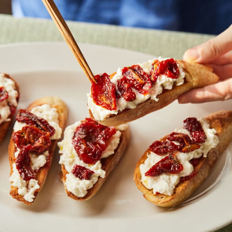 페이스트 위에 부라타치즈를 올리고 선 드라이 토마토와 바질잎을 올려주세요.