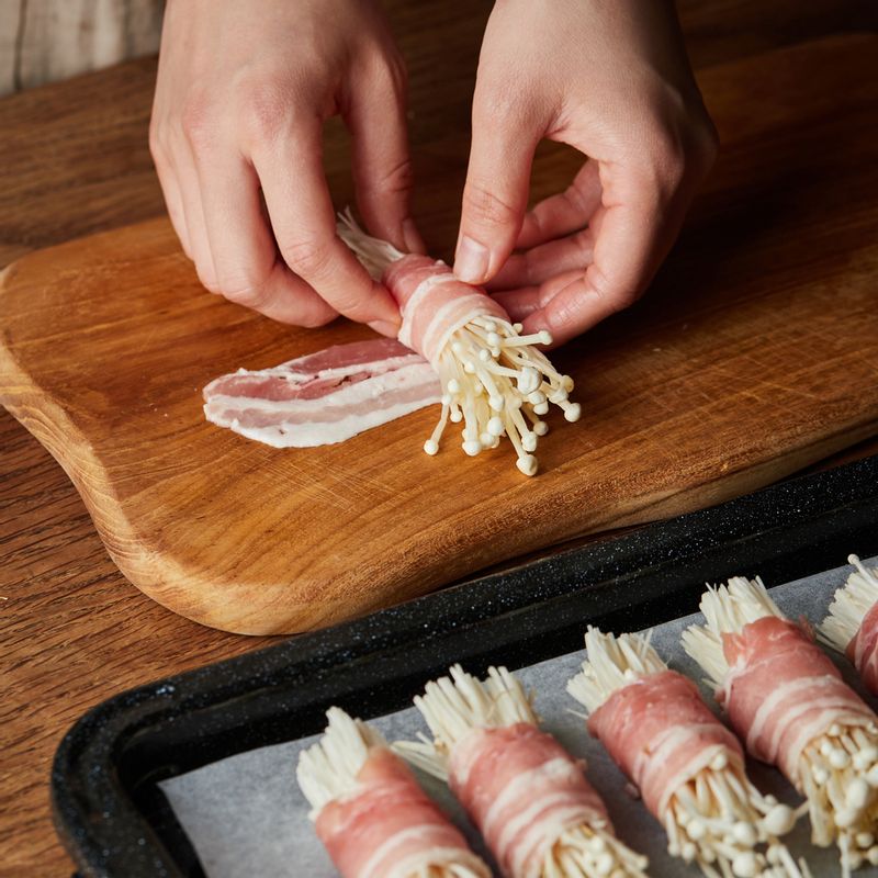 삼겹살 끝에 팽이버섯을 넣고 돌돌 말아 법랑 접시에 가지런히 올리고 통마늘을 올려주세요.
(tip. 삼겹살의 이음새가 아래로 가도록 놓아주세요)