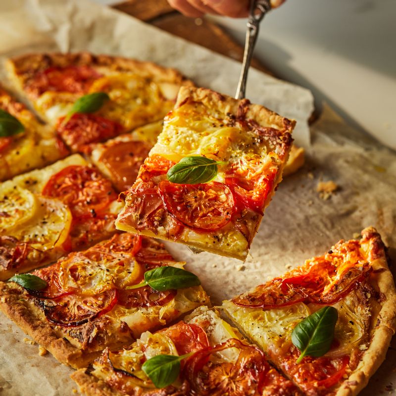 토마토 타르트에 바질을 올려주세요. 적당한 크기로 잘라 맛있게 즐겨주세요.