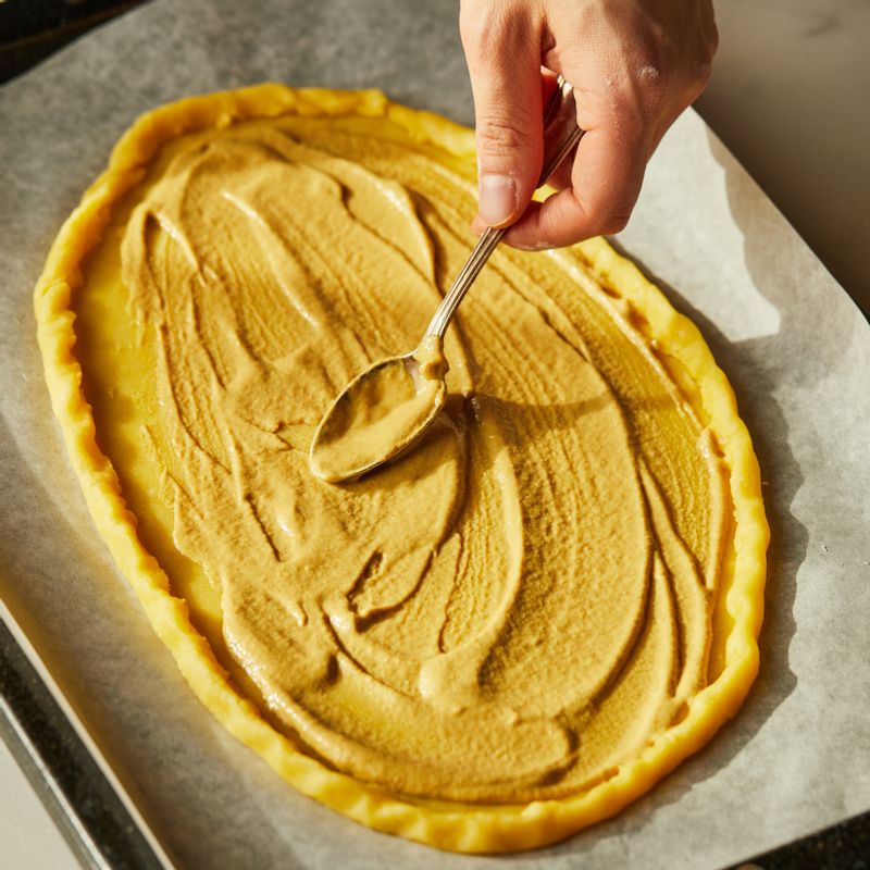 펼친 반죽을 법랑 접시에 올리고 가장자리를 말아 준 후 디종 머스타드 - 빵가루 - 모짜렐라 치즈 - 토마토 순으로 올리고 소금, 후춧가루를 뿌려주세요.