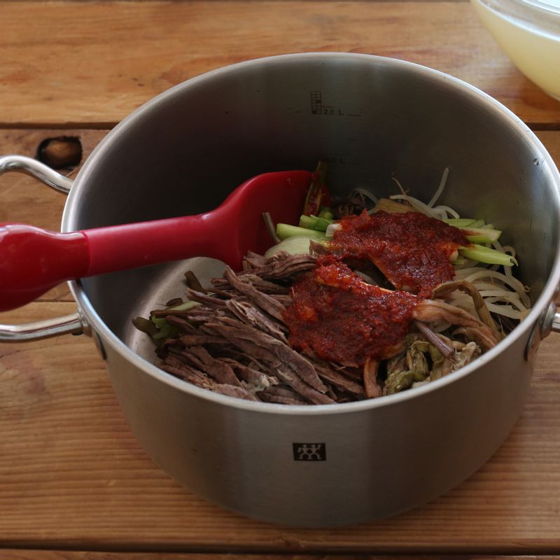 냄비에 쇠고기, 대파, 숙주, 고사리, 느타리버섯, 토란대, 양념 재료를 넣어 버무려주세요.